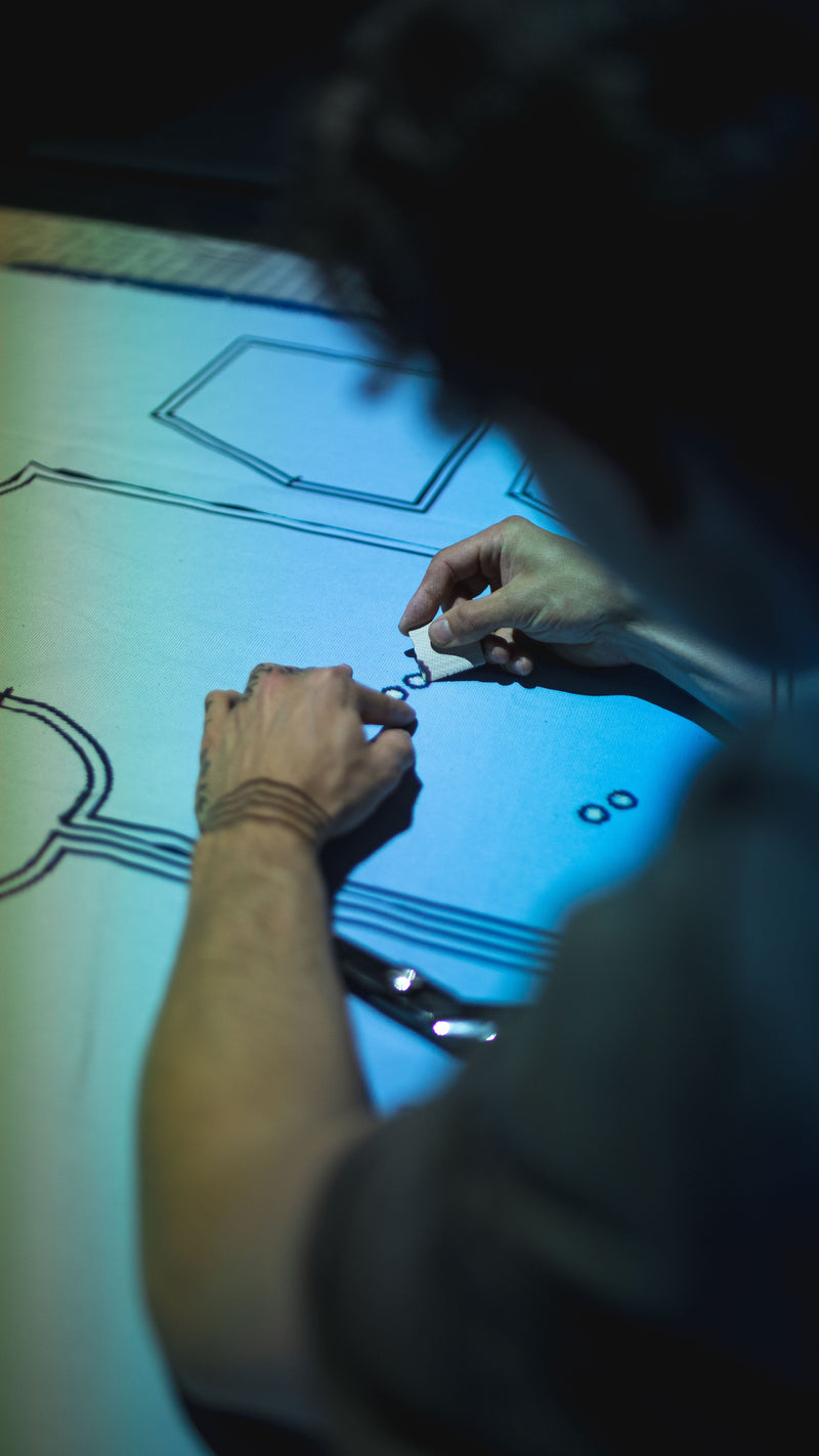 Fashion designer working on detailed clothing sketches at In-House studio.