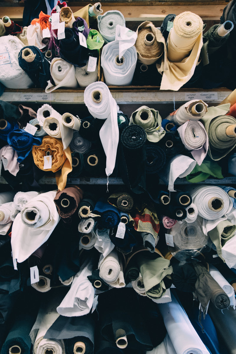 Rolls of colorful fabric stacked together for selection in a warehouse.