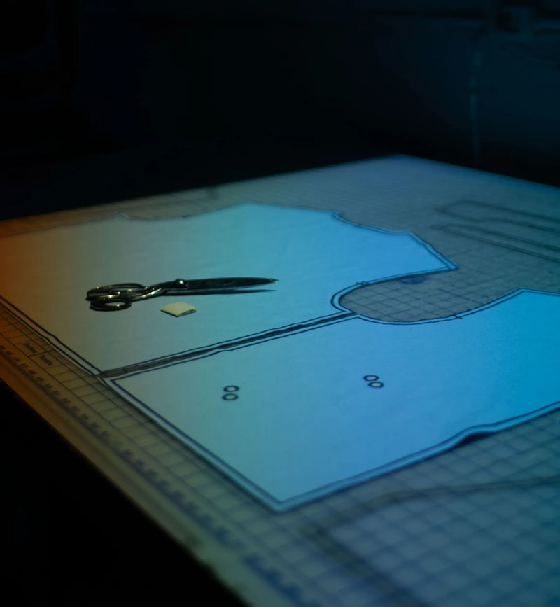 Clothing pattern pieces and fabric templates arranged on a cutting table during apparel production.