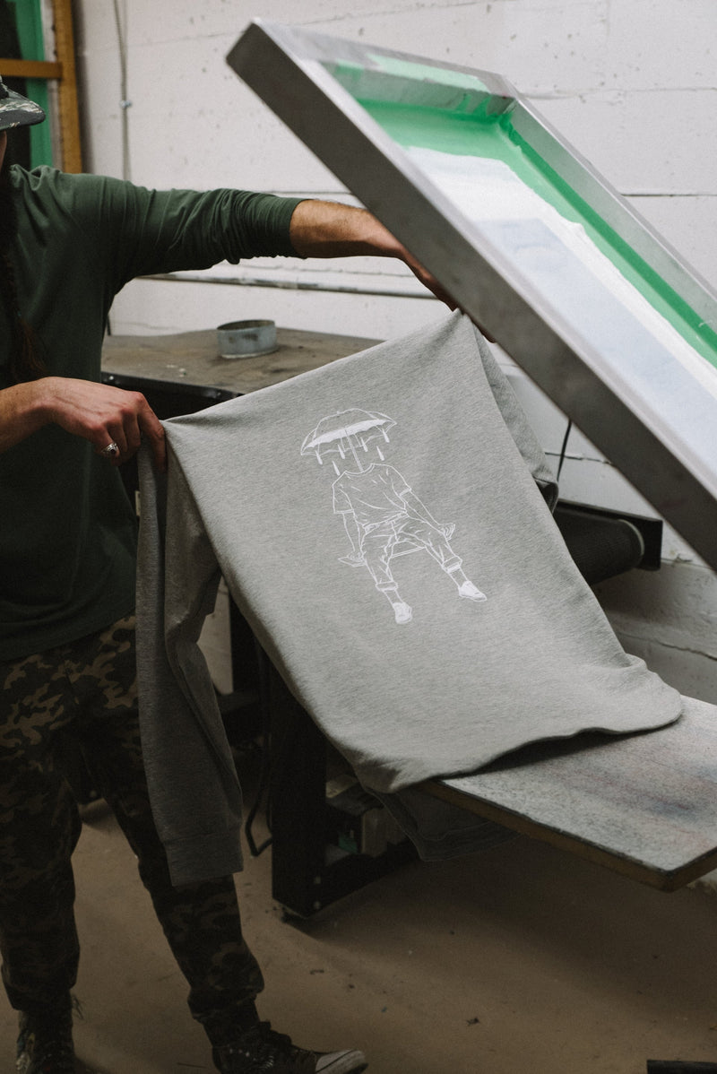 A person is taking the printed T-shirt from the manufacturing unit at In-House. 
